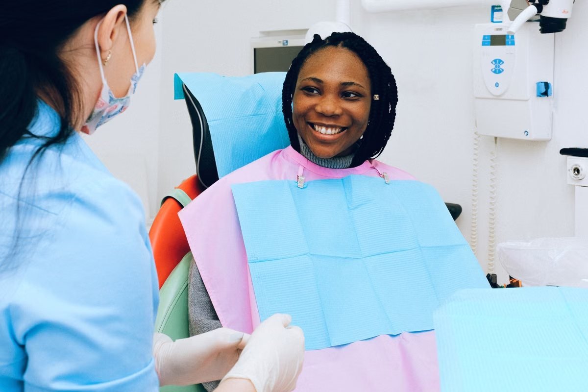 A smiling patient talking with her dentist
